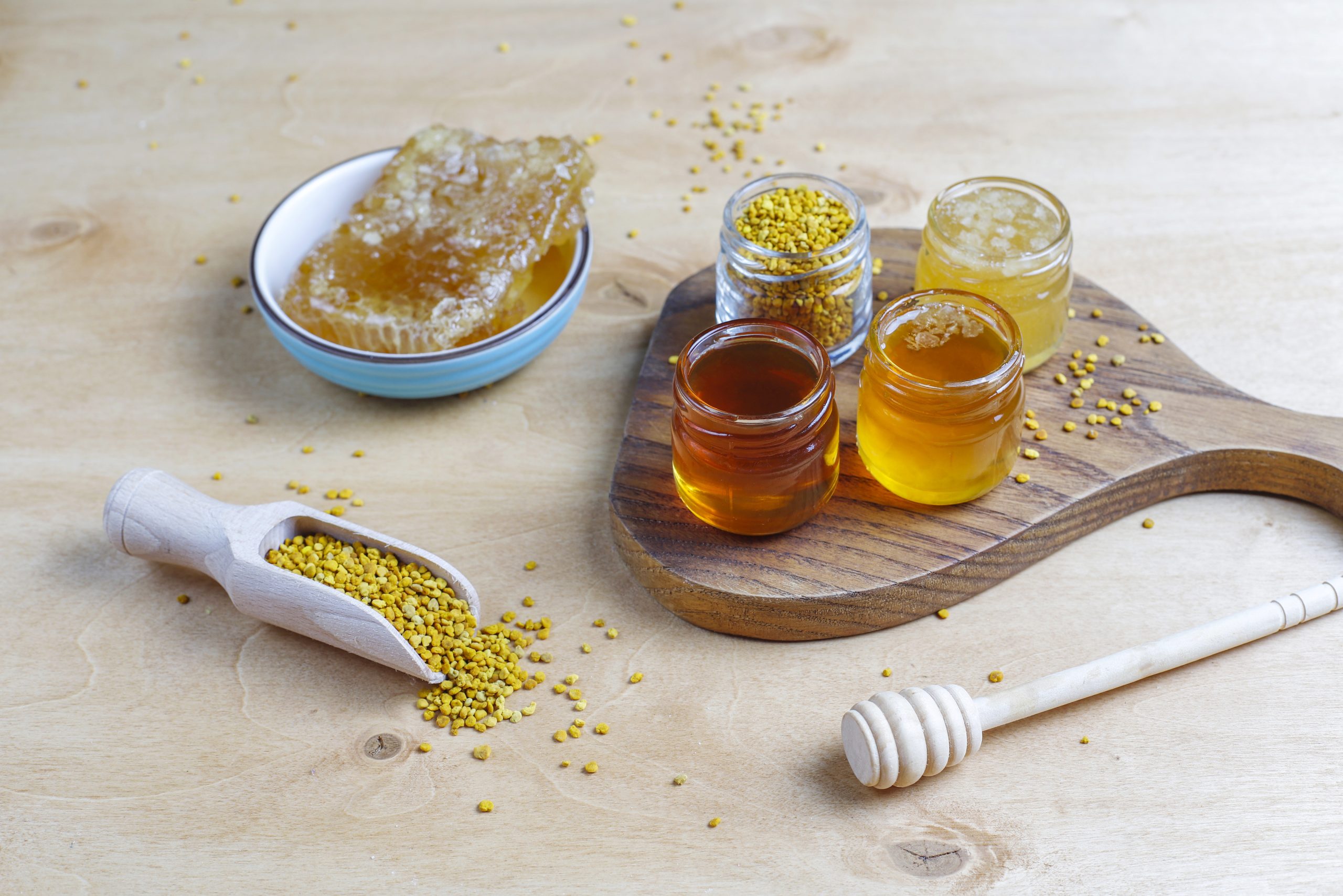 Various kinds of honey in glass jars,honeycomb and pollen.
